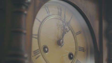 Beautiful-shot-of-a-detail-of-a-1920s-deli-pendulum-clock-from-the-1900s,-a-vintage-ancestral-object-with-decorated-hands-and-Roman-numerals-to-mark-time