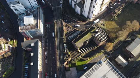 Aerial-drone-flight-showing-a-birdseye-view-of-the-railway-line-from-Deansgate-Station-to-Oxford-Road-train-Station-in-Manchester-City-Centre