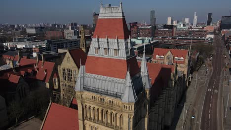 Aerial-drone-flight-around-the-rooftops-of-The-University-of-Manchester-showing-the-architecture-and-the-City-Centre-in-the-distance