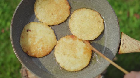 Potato-pancakes-baking-in-a-pan-with-oil-outside-during-the-summer