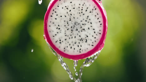 Water-Flowing-Down-Fresh-Dragon-Fruit-Slice-in-Slow-Motion-with-Bright-Backlit-Background