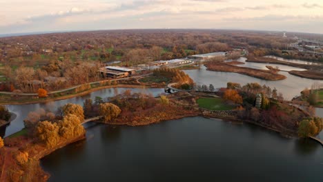 Glencoe,-Illinois,-USA-:-Aerial-drone-forward-moving-shot-over-Chicago-Botanic-Garden-during-dry-autumn-season-with-small-lakes-during-evening-time