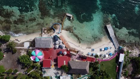 Aerial-drone-bird's-eye-view-over-beautiful-beach-club-at-Isla-Mujeres-island-in-Quintana-Roo,-Mexico-at-daytime