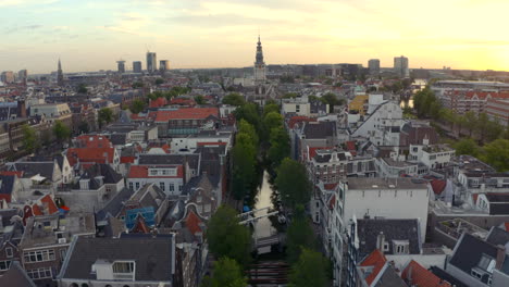Beautiful-descending-drone-shot-of-small-Amsterdam-canal-and-Zuiderkerk-Church