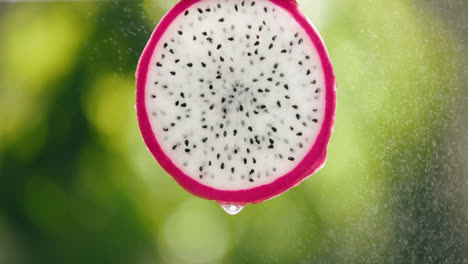 Dragon-Fruit-Slice-Splashed-by-Strong-Water-Droplet-Mist-with-Liquid-Drip-in-Slow-Motion-Bright-Backlit-Background