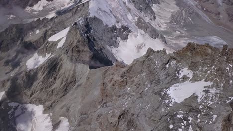 View-of-rugged-terrain,-snow-and-ice-below-Carell-Hut-on-side-of-mountain-in-Alps-below-The-Matterhorn
