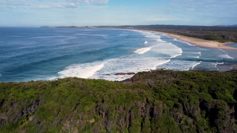 Drone-aerial-pan-landscape-shot-of-National-Park-bushland-scenery-view-Pacific-Ocean-waves-on-sandy-beach-Old-Bar-Point-travel-tourism-Taree-Saltwater-NSW-Australia-4K
