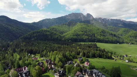 Landscape-fly-by-of-the-legendary-Giewont-peak-in-the-Polish-Tatry-Mountains,-farmland,-forests-near-Zakopane,-Poland,-a-resort-town-with-traditional-Goral-architecture-3