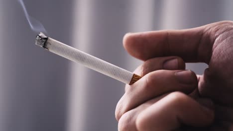 Person-Hält-Eine-Zigarette,-Während-Sie-Raucht,-Unscharfer-Hintergrund