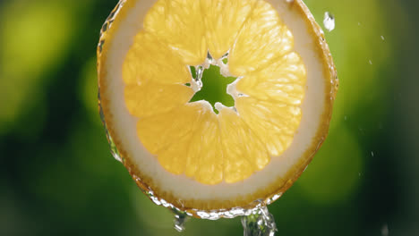 Water-Flowing-Down-Fresh-Orange-Slice-in-Slow-Motion-with-Bright-Backlit-Background