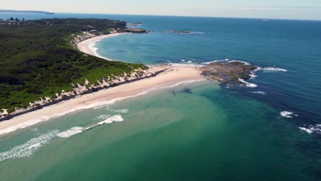 Drone-aerial-pan-shot-of-scenic-landscape-view-of-Ocean-beautiful-bushland-sandy-beach-Norah-Head-Soldiers-Beach-Central-Coast-tourism-travel-explore-NSW-Australia-4K