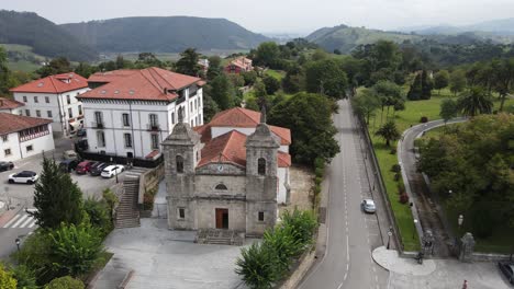 Aerial-shot-of-an-old-church-in-Colombres-with-mountains-and-green-countryside-in-the-surrounding-area