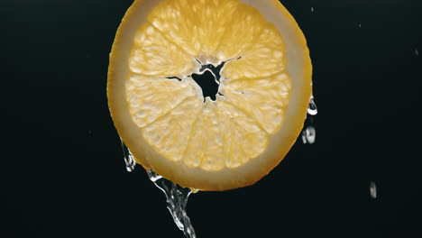 Wasser,-Das-Frische-Orangenscheibe-In-Zeitlupe-Mit-Hintergrundbeleuchtetem-Schwarzem-Hintergrund-Herunterfließt
