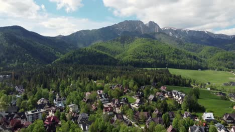 Landscape-fly-by-of-the-legendary-Giewont-peak-in-the-Polish-Tatry-Mountains,-farmland,-forests-near-Zakopane,-Poland,-a-resort-town-with-traditional-Goral-architecture-4