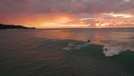 Surfer-Fangende-Welle-Mit-Wunderschönem-Hawaii-sonnenunterganghintergrund,-Luftdrohnenflug