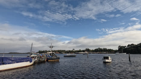 Boats-floating-on-the-water-on-a-sunny-day-in-Strahan,-West-Coast-of-Tasmania