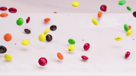 Colorful-m-and-m-candies-falling-onto-white-plate-and-dancing-around-in-slow-motion