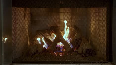 Static-shot-of-Flames-in-indoor-fireplace-through-grid-guard,-Slow-motion