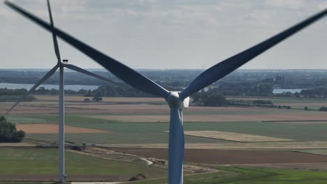 Aerial-orbit-shot-of-rotating-wind-turbines-and-Delta-Works-in-Oosterscheldekering,Netherlands