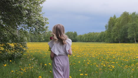 Blonde-Little-Girl-Holds-Rose-Walking-Over-Blooming-Summer-Meadow