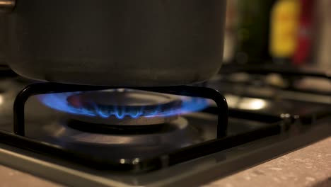 Turning-gas-stove-up-with-pot-on-top-close-up,-slow-motion