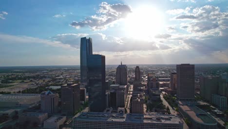 Drone-footage,-4K,-downtown-Oklahoma-City,-at-sunset,-rain-clouds-in-background,-of-Devon-tower
