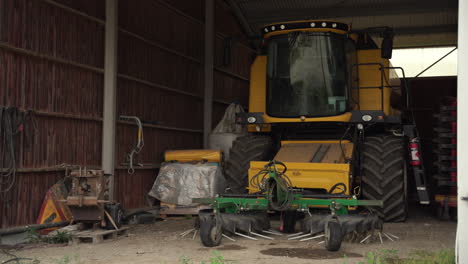 Medium-shot-of-combine-harvester-parked-in-a-barn