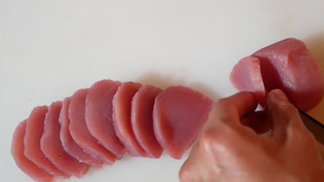 Hand-Use-Knife-to-Slice-Pink-Maguro-into-Small-Bite-Sashimi,-Close-Up