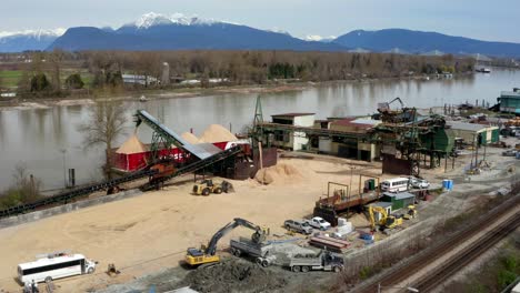Loading-Sand-Barge-And-Trans-Mountain-Pipeline-Alongside-Fraser-River-In-Port-Kells,-Surrey,-BC,-Canada