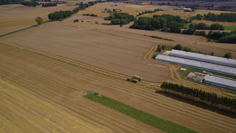 Aerial-flyover-combine-harvester-and-tractor-during-work-process-on-wheat-field