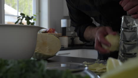 Man-Shredding-Cabbage-for-Sauerkraut-or-Kimchi,-Dolly-Slide,-Close-Up