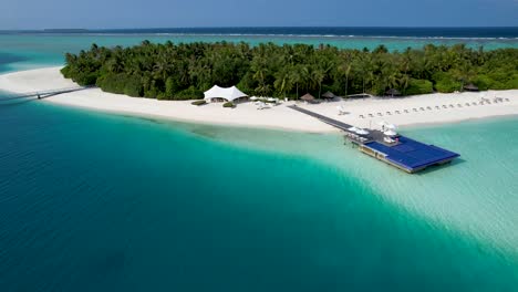 Aerial-view-of-maldives-beach-with-infinity-pool-over-ocean-and-palm-trees