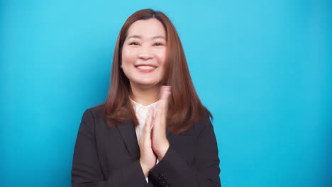 Portrait-positive-Asian-businesswoman-smiling-and-successful-with-a-hand-clap-for-congratulation-on-blue-background