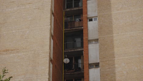 A-tilt-up-slow-motion-shot-revealing-the-balconies-of-an-old-communist-building-in-Bucharest,-Romania