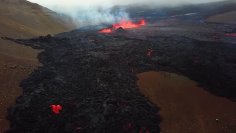 Aerial-landscape-view-of-lava-erupting-in-Meradalir-valley,-from-Fagradalsfjall-volcano,-with-smoke-coming-out