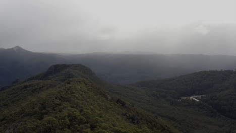 Aerial:-Drone-flying-over-a-forested-ridge-line-near-Cradle-Mountain,-Tasmania