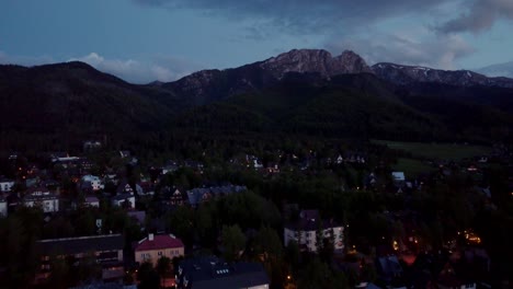 Night-time-flyover-of-Zakopane,-Poland,-a-resort-town-against-the-Tatra-Mountains,-and-its-stunning-Goral-traditional-architecture-1