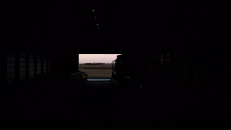 Drone-flight-through-a-farm-hangar-in-the-north-American-prairies-at-nightfall