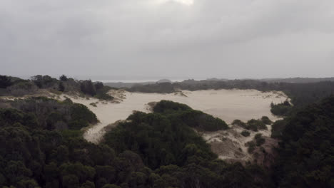 Aerial:-Drone-flying-towards-a-sand-dune-near-Strahan,-Tasmania-Australia