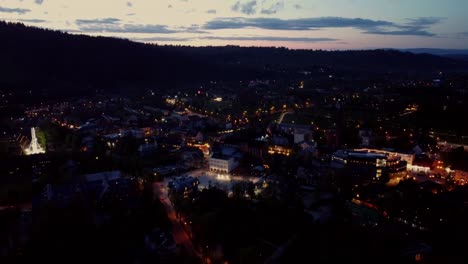 Night-time-flyover-of-Zakopane,-Poland,-a-resort-town-against-the-Tatra-Mountains,-and-its-stunning-Goral-traditional-architecture-3