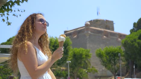 Woman-eating-an-ice-cream-and-enjoying-the-view-in-Collioure,-France