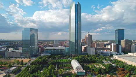 4K-Drone-footage-of-a-sunny-day-in-downtown-Oklahoma-City-metro,-Myriad-botanical-gardens,-green-city-park,-huge-clouds,-rain-background