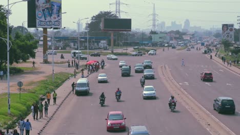Downtown-Kinshasa-skyline-behind-boulevard-Lumumba-traffic---Congo-DRC