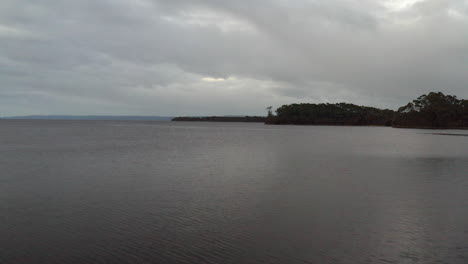 Aerial:-Drone-flying-over-a-large-lake-on-a-moody-overcast-day-on-the-West-Coast-of-Tasmania