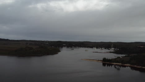 Aerial:-Drone-flying-towards-a-harbour-of-boats-in-Tasmania