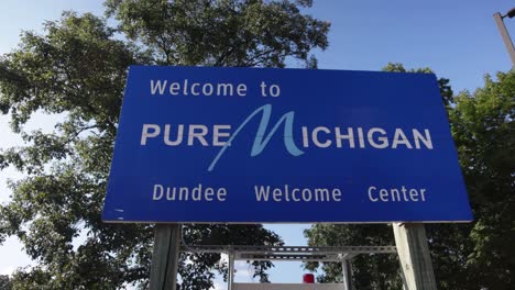Pure-Michigan-welcome-sign-in-Dundee,-Michigan-with-gimbal-video-panning-left-to-right-in-slow-motion