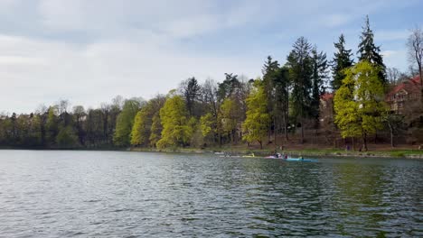 Group-of-kayakers-kayaking-on-dam-or-lake-in-Liberec,-Czech-Republic,-wide-angle-view,-sunny-day