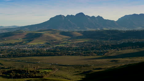 Vehicle-traffic-at-the-foot-of-Sir-Lowry's-Pass,-Helderberg-in-background