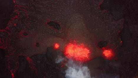Aerial-top-view-over-magma-and-lava-erupting-in-Meradalir-valley,-from-Fagradalsfjall-volcano,-with-smoke-coming-out