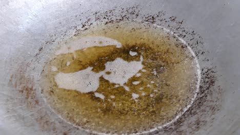Adding-Mashed-Garlic,-Coriander-Root-and-Pepper-to-Boiling-Oil,-Close-Up